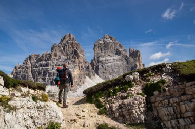 Dolomites, İtalya 'da Tre Cime di Lavaredo' nun etkileyici zirvelerinin çarpıcı güzelliğine hayran kalan bir yürüyüşçü..