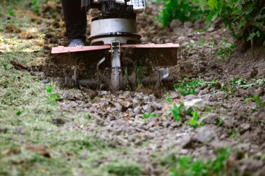Çiftçi adam ekiciyle toprağı sürüyor toprağı ekime hazırlıyor..