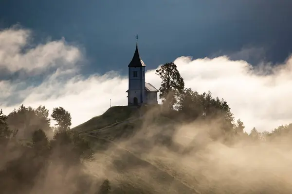 Jamnik 斯洛文尼亚 詹姆尼克教堂 Jamnik Church 是一座迷人的15世纪小礼拜堂 座落在克兰附近的卡姆尼克 萨文加阿尔卑斯山畔 俯瞰着周围的山景 令人叹为观止 免版税图库照片