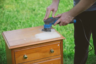 Elektrikli zımpara makinesiyle odun öğütüyorum. Yaratıcı tasarım, ev yenileme teması, DIY konsepti