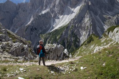 Dolomitler, İtalya 'da, Tre Cime di Levaredo' nun bir parçası olan Cadini di Misurina dağ grubunun etkileyici sivri tepelerinin büyüleyici güzelliğine hayran kalan bir adam yürüyüşçüsü..