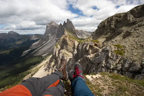 イタリアのセーダ ドロマイト山脈の高い山頂に座っている旅行者のカップルの足 自由の概念 夏休みの活動 ロイヤリティフリーのストック画像