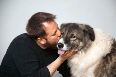 Evinde sevimli, mutlu köpeğiyle beyaz yakışıklı bir adam..
