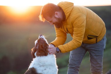 Doğada bir adam köpeğiyle, sevgi gösteriyor..