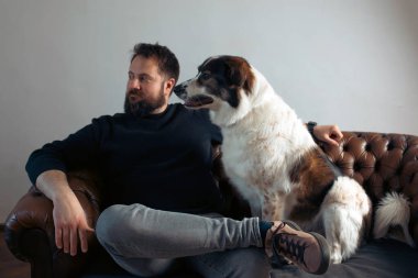 Evinde sevimli, mutlu köpeğiyle beyaz yakışıklı bir adam..