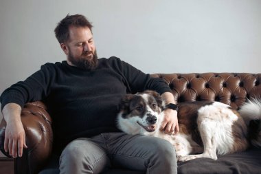 Evinde sevimli, mutlu köpeğiyle beyaz yakışıklı bir adam..