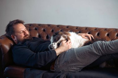 Evinde sevimli, mutlu köpeğiyle beyaz yakışıklı bir adam..