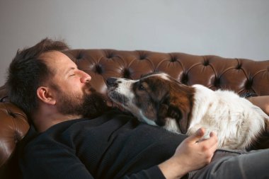 Evinde sevimli, mutlu köpeğiyle beyaz yakışıklı bir adam..