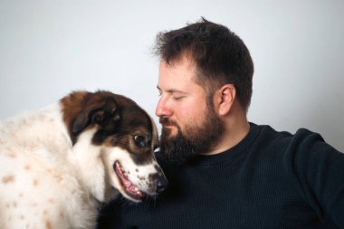 Evinde sevimli, mutlu köpeğiyle beyaz yakışıklı bir adam..