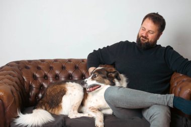 Evinde sevimli, mutlu köpeğiyle beyaz yakışıklı bir adam..