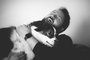 Evinde sevimli, mutlu köpeğiyle beyaz yakışıklı bir adam..