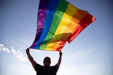 Man holding a Gay Rainbow Flag. Happiness, freedom and love concept for same sex couples