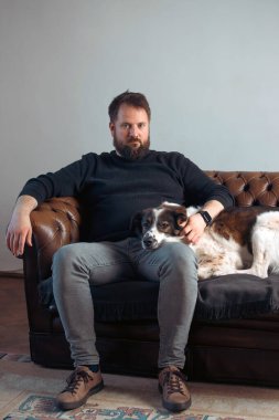 Evinde sevimli, mutlu köpeğiyle beyaz yakışıklı bir adam..
