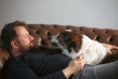 Evinde sevimli, mutlu köpeğiyle beyaz yakışıklı bir adam..