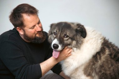 Evinde sevimli, mutlu köpeğiyle beyaz yakışıklı bir adam..