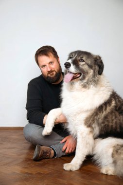 Evinde sevimli, mutlu köpeğiyle beyaz yakışıklı bir adam..