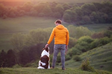 Doğada insan ve köpeği sihirli günbatımında