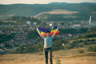 Woman holding a Gay Rainbow Flag. Happiness, freedom and love concept for same sex couples