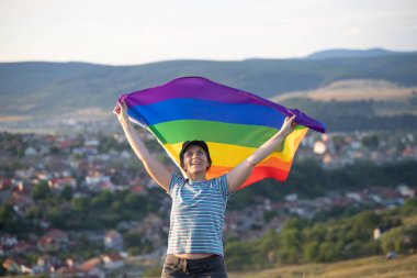 Woman holding a Gay Rainbow Flag. Happiness, freedom and love concept for same sex couples