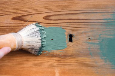 İnsan eli tebeşirle ahşap mobilya boyuyor. Yepyeni renkli tebeşir boyasıyla eski moda ahşap mobilyaları yeniliyorum. Ev dekorasyonu yeniden biçimlendiriliyor