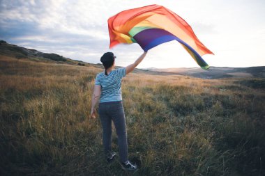 Woman holding a Gay Rainbow Flag.Happiness, freedom and love concept for same sex couples