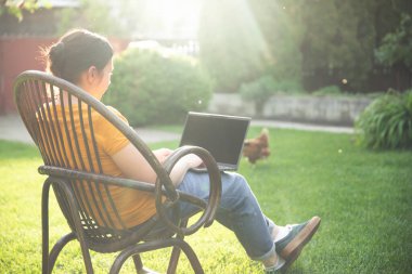 Evden çalışmak ya da internetten çalışmak, dışarıda dizüstü bilgisayarda çalışan bir kadınla çalışmak..