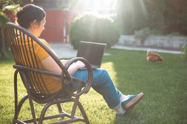 Evden çalışmak ya da internetten çalışmak, dışarıda dizüstü bilgisayarda çalışan bir kadınla çalışmak..