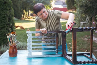 Evdeki mobilyaları zımparalayan kadın, yer değiştirme ve konsept..