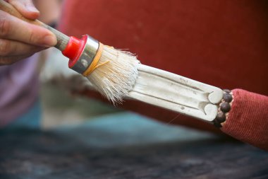İnsan eli tebeşirle ahşap mobilya boyuyor. Yepyeni renkli tebeşir boyasıyla eski moda ahşap mobilyaları yeniliyorum. Ev dekorasyonu yeniden biçimlendiriliyor