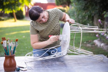 Orta boyalı kadın evde demir sandalye dövmesi, taşınma ve sönme konsepti..