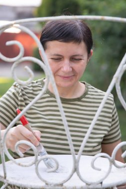 Orta boyalı kadın evde demir sandalye dövmesi, taşınma ve sönme konsepti..