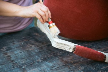 İnsan eli tebeşirle ahşap mobilya boyuyor. Yepyeni renkli tebeşir boyasıyla eski moda ahşap mobilyaları yeniliyorum. Ev dekorasyonu yeniden biçimlendiriliyor