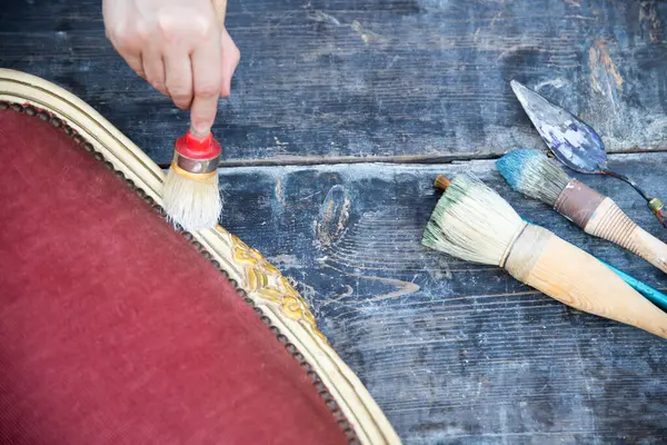 İnsan eli tebeşirle ahşap mobilya boyuyor. Yepyeni renkli tebeşir boyasıyla eski moda ahşap mobilyaları yeniliyorum. Ev dekorasyonu yeniden biçimlendiriliyor