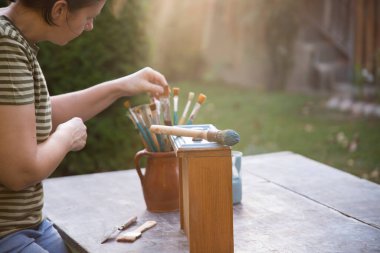 Evdeki mobilyaları boyayan orta yaşlı kadın, yer değiştirme ve konsept..