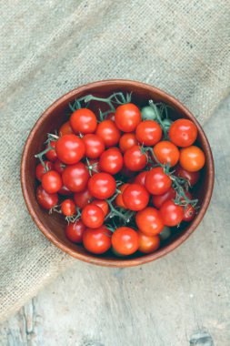 Köy arka planında bir kasede olgun sulu vişneli domatesler. Sağlıklı vejetaryen gıda kavramı. 