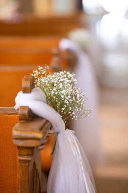 Beyaz çiçekli ve peçeli bir kilisenin içinde düğün süsü..