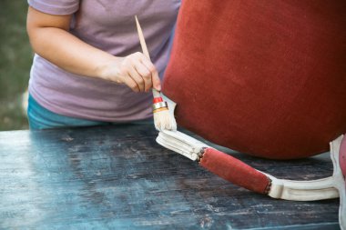İnsan eli tebeşirle ahşap mobilya boyuyor. Yepyeni renkli tebeşir boyasıyla eski moda ahşap mobilyaları yeniliyorum. Ev dekorasyonu yeniden biçimlendiriliyor