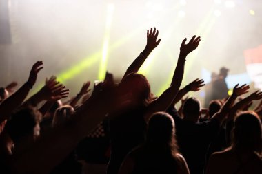 Konserde kalabalık - Parlak renkli sahne ışıkları önünde tezahürat yapan kalabalık