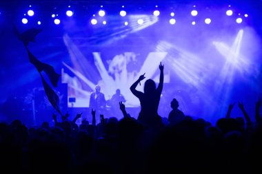 Konserde kalabalık - Parlak renkli sahne ışıkları önünde tezahürat yapan kalabalık