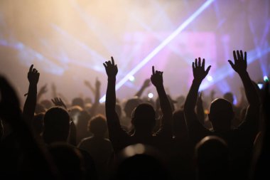 Konserde kalabalık - Parlak renkli sahne ışıkları önünde tezahürat yapan kalabalık