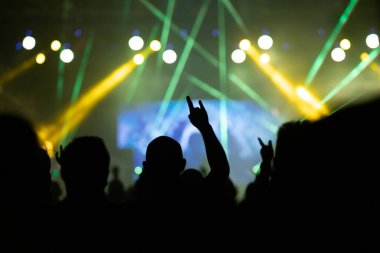 Konserde kalabalık - Parlak renkli sahne ışıkları önünde tezahürat yapan kalabalık