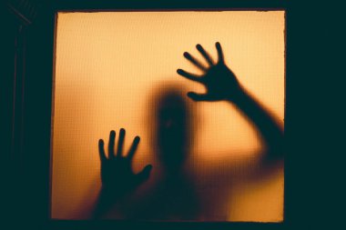 Korku, cadılar bayramı arkaplanı Bir adamın camının arkasındaki gölgeli figür