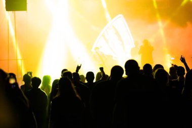 Konserde kalabalık - Parlak renkli sahne ışıkları önünde tezahürat yapan kalabalık