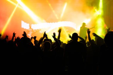 Konserde kalabalık - Parlak renkli sahne ışıkları önünde tezahürat yapan kalabalık