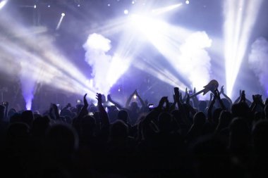 Konserde kalabalık - Parlak renkli sahne ışıkları önünde tezahürat yapan kalabalık