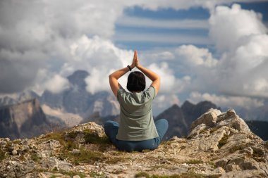 Kadın Dolomite dağlarında yoga yapıyor. Canlılık, denge, farkındalık, zen enerjisi, sakinlik, rahatlama kavramı..