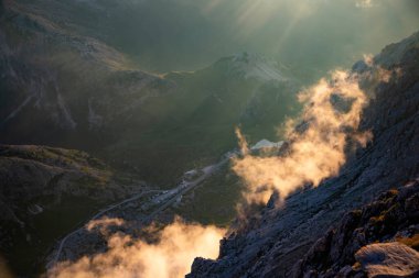 Dolomite dağlarında gün batımı oyunları ve sis Rifugio Lagazuoi 'nin en yüksek tepelerinde görüldü. Muhteşem bir yaz günbatımında..