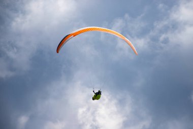 Mavi gökyüzünde bulutlarla uçan paraglider. Macera konsepti..