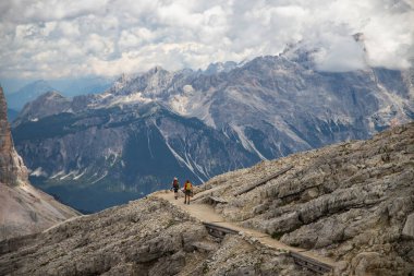 Trekker couple on Lagazuoi mountain, enjoying picturesque Dolomite Alps in Italy. Active people and mountain concept. clipart