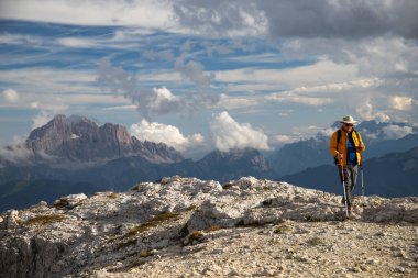 Man trekker on the top of Lagazuoi, enjoying picturesque Dolomite Alps view in Italy. Active people and mountain concept. clipart